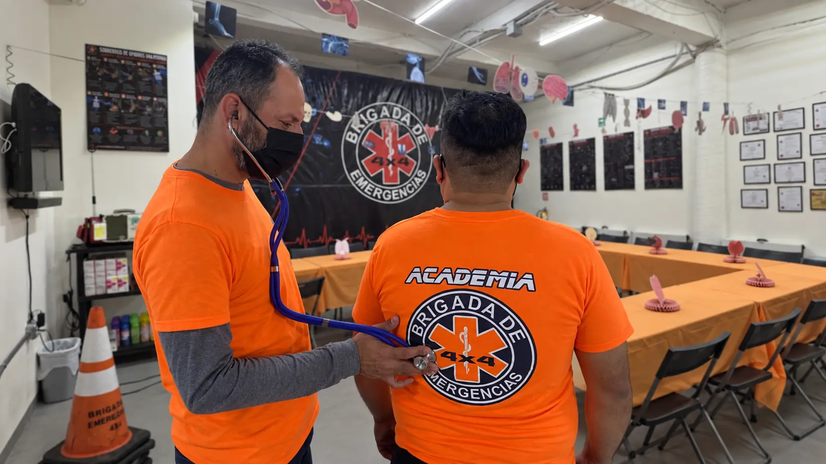 Instructor y alumno practicando auscultación en el aula de la Academia